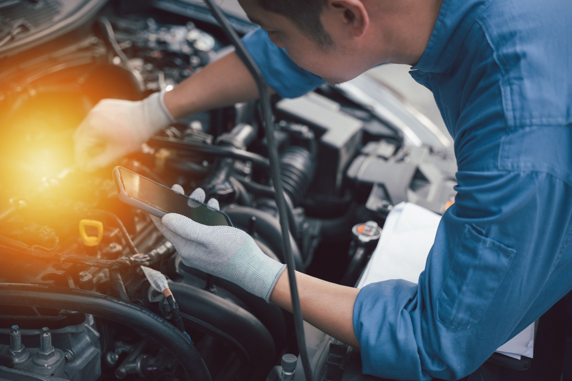 Mechanic use smartphone repair car.